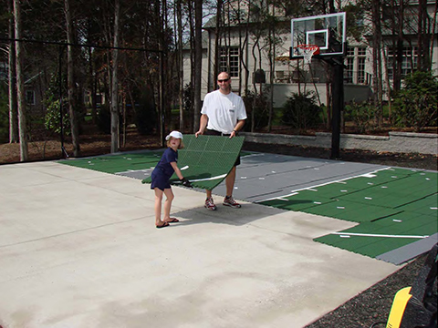 man and daughter installing court tiles